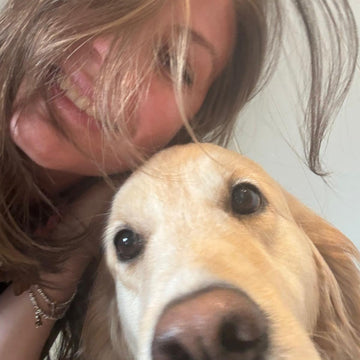 woman with a golden retriever, both looking at the camera